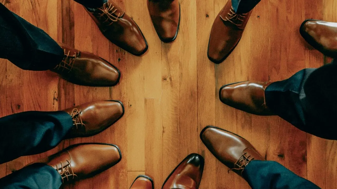 Overhead view of the groom and groomsmen's polished dress shoes in a circle