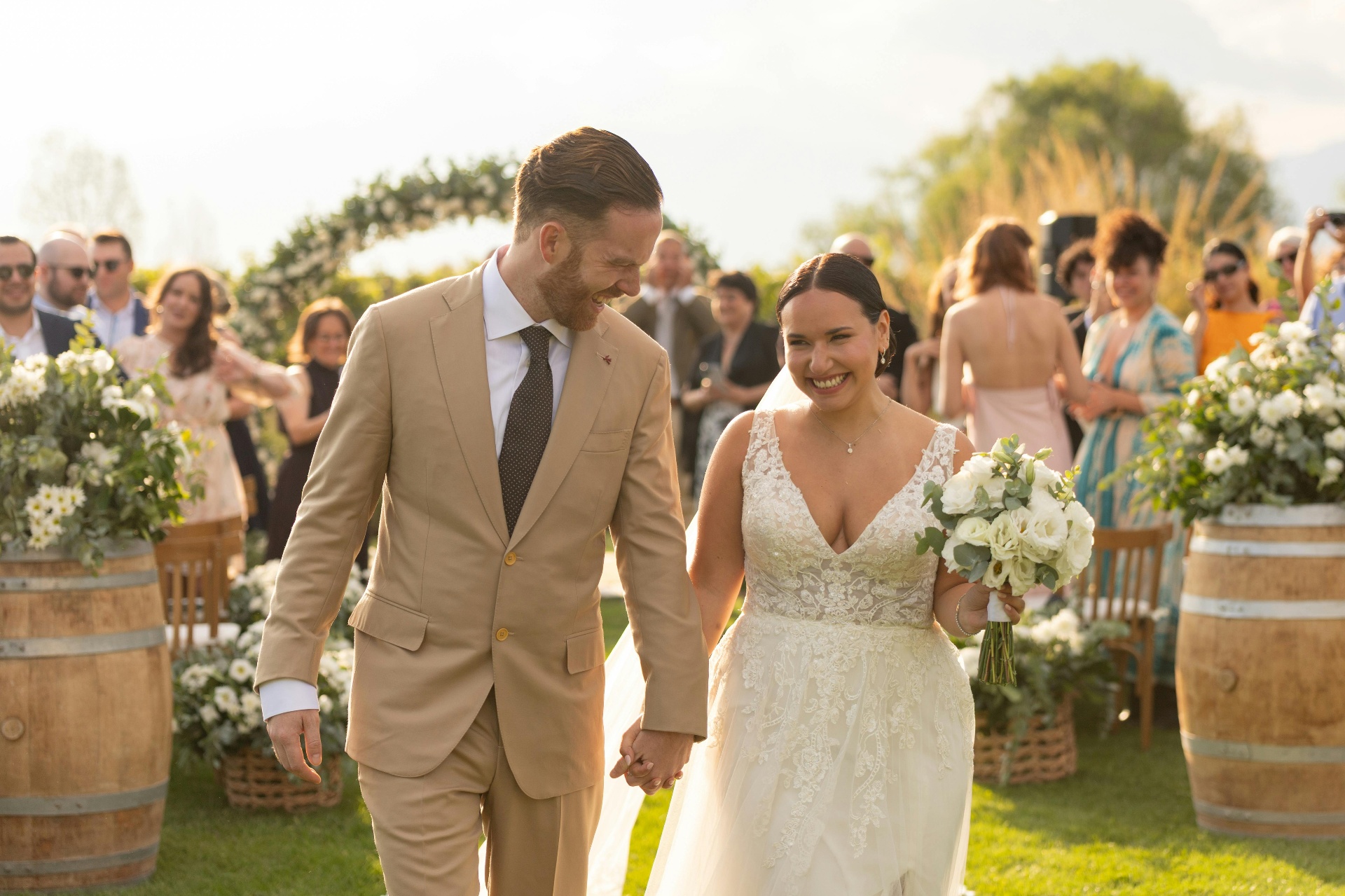 Happy bride and groom walking down the aisle together after their outdoor wedding ceremony